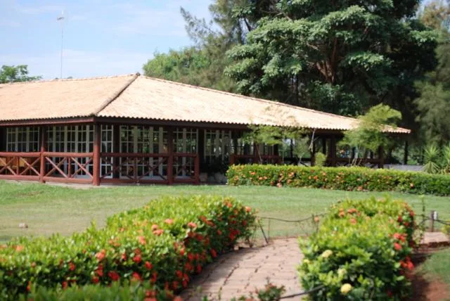 Fachada do restaurante, com telhado colonial e jardim florido
