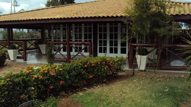 Prédio do restaurante visto do jardim, com canteiros floridos