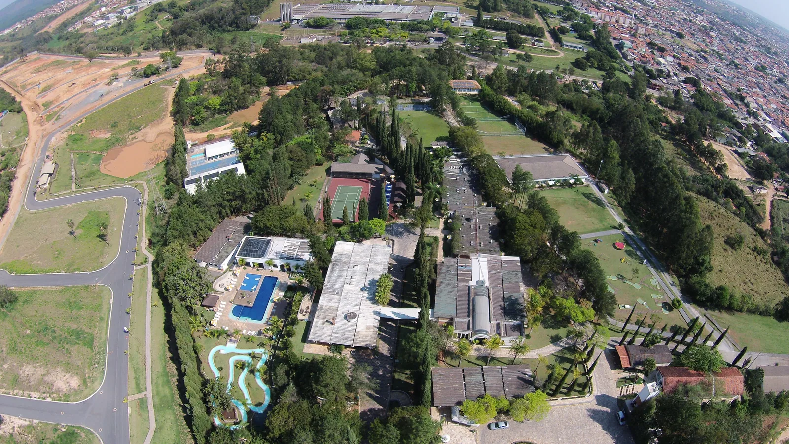 Vista aérea do Spa Med, com os blocos, as piscinas e a quadra entre a mata