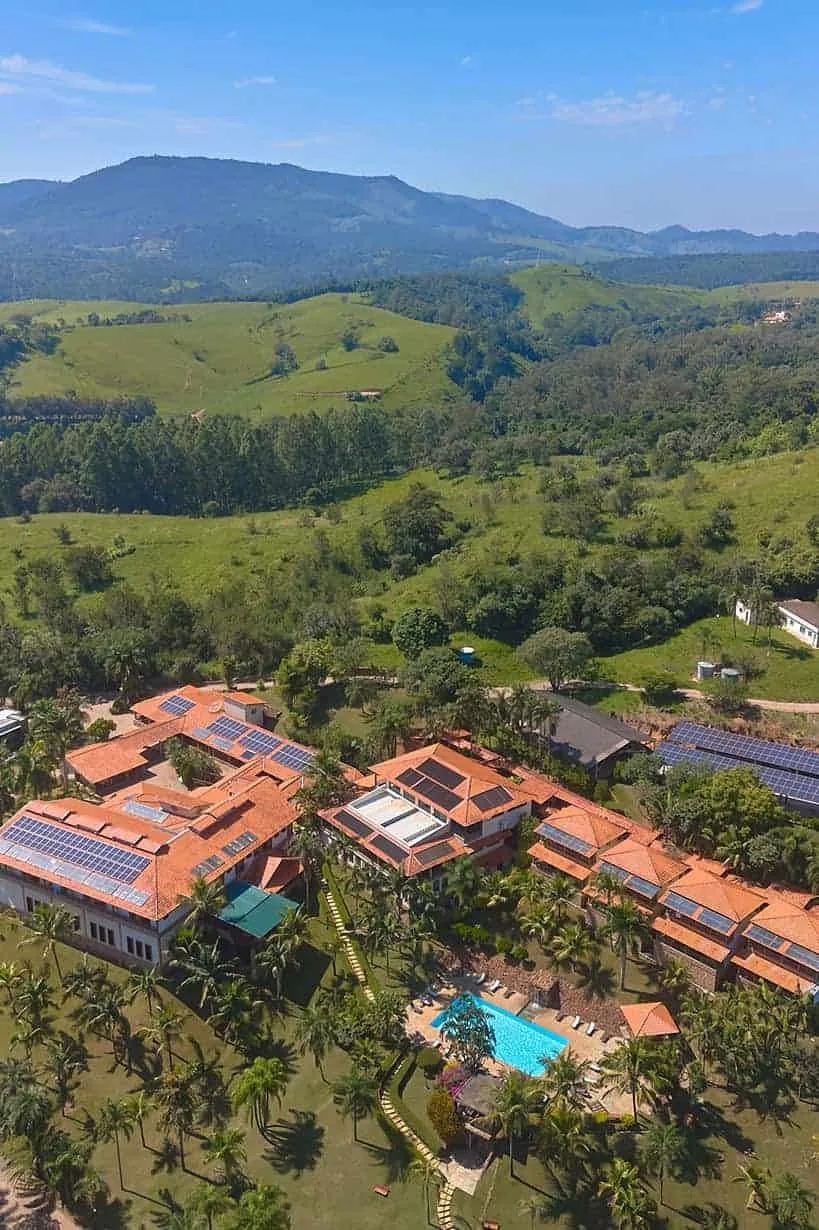 Vista aérea do conjunto do spa, com telhados vermelhos e os morros da Serra do Japi ao fundo